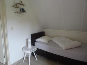 een kleine slaapkamer met een bed en een kleine tafel bij Kustverhuur, Park Schoneveld, Stern 234 met eigen elektrische laadpaal in Breskens