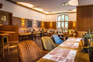 um restaurante com mesas e cadeiras de madeira e mesa em Berghotel Friedrichshöhe em Kurort Altenberg