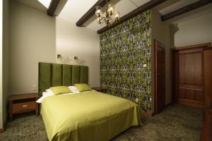 a bedroom with a bed with a green headboard at Dworek Biały Domek in Smardzewice