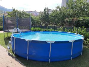 a large blue hot tub in a yard at Apartments Babic in Podstrana