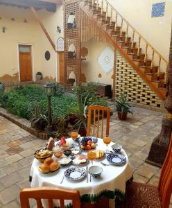 a table with food on it in a courtyard at Qosha Darvoza in Khiva