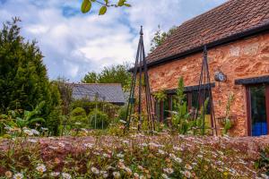 een tuin voor een bakstenen huis bij The Old Bookshop in Williton