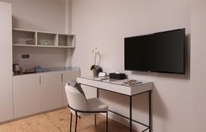 a room with a desk with a tv on a wall at The Pearl Suites in Istanbul