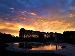 a sunset over a pond in a garden at Agriturismo Casalbergo in Isola della Scala