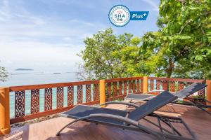Phi Phi Natural Resort-SHA Extra Plus في جزيرة في في: وجود زوج من الكراسي على سطح يطل على الماء