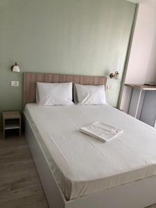 ein weißes Bett mit einem Tablett darüber in der Unterkunft Vila Bordei Verde in Mamaia Nord – Năvodari