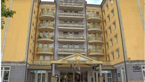 a large building with a sign in front of it at Palota Apartman in Hévíz