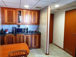 a kitchen with wooden cabinets and a table in a room at Palota Apartman in Hévíz