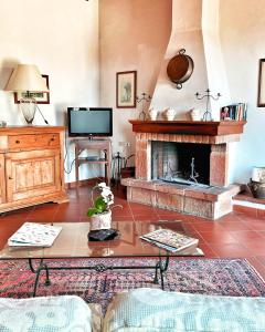 a living room with a fireplace and a tv at Tenuta Lupinari in Bucine