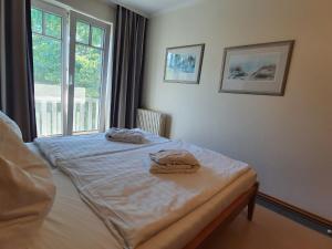 1 dormitorio con 1 cama con 2 toallas en Dünenpark Binz - Komfort Ferienwohnung mit 1 Schlafzimmer und Balkon im Dachgeschoss 282, en Binz