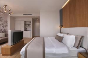 A bed or beds in a room at The Pearl Suites