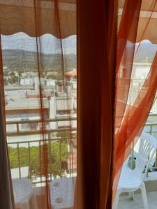 a view of a balcony from a window with a view of a city at Hotel Strimoniko in Asprovalta