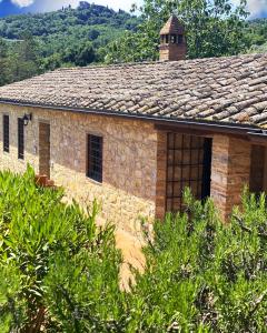 an old stone building with a chimney on it at Tenuta Lupinari in Bucine