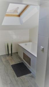 a white bathroom with a sink and a skylight at Ferienwohnung "Burgblick" in Heldrungen