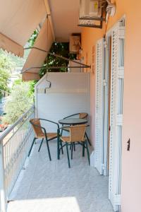 a patio with a table and chairs on a balcony at Hotel Loula Rooms and Apartments in Kamena Vourla
