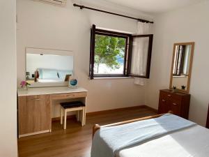 Schlafzimmer mit einem Bett, einem Schreibtisch und einem Spiegel in der Unterkunft Sea & Relax in Selca