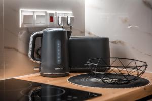 a black coffee maker on a counter next to a toaster at COSea Living: SeaSide Luxury Suite in Harbour 107A in Paphos City