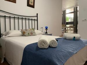 a bedroom with a bed with towels on it at Apartamentos La Casa del Azafrán in Córdoba