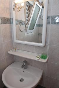 a bathroom sink with a mirror above it at Hotel Loula Rooms and Apartments in Kamena Vourla