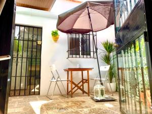 een patio met een tafel en een parasol bij Apartamentos La Casa del Azafrán in Córdoba