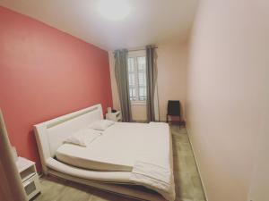 um quarto com uma cama branca e uma janela em La Maison de Rose em Cassis