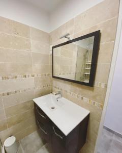 uma casa de banho com um lavatório e um espelho em La Maison de Rose em Cassis