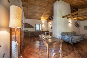 a dining room with a table and chairs and a couch at L'Atelier du Temps - Baita Grandes Jorasses in Montita