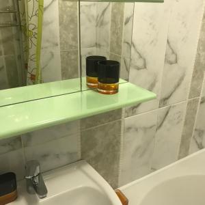 基辅Апартаменты Ботанический Сад的浴室在水槽上方的架子上设有两把蜡烛