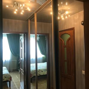 Zimmer mit einem Schlafzimmer mit einem Spiegel und einem Bett in der Unterkunft Апартаменты Ботанический Сад in Kiew