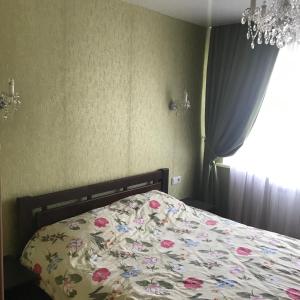 基辅Апартаменты Ботанический Сад的卧室里有一张铺着花卉床罩的床