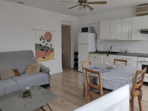 a kitchen and a living room with a table and a couch at La maisonnette de Saint Chamas in Saint-Chamas