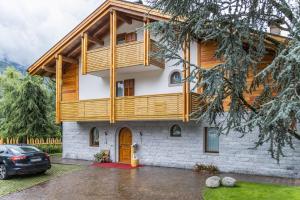 a house with a wooden balcony on top of it at Chalet Mountain Plaza - Apt Overland in Pinzolo