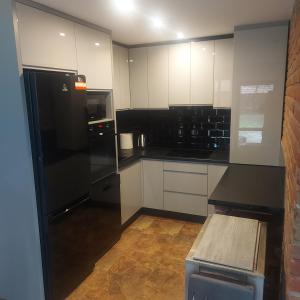 a kitchen with black appliances and white cabinets at Szewnia Dolna in Szewnia +68 photos
