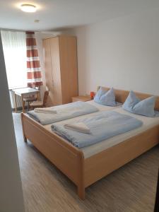 a bedroom with two beds and a table and a chair at Pension Stanek in Hofkirchen