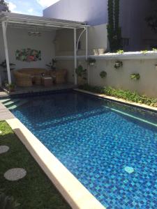 a swimming pool with blue water in a yard at Omah Kumpul Sentul in Bogor