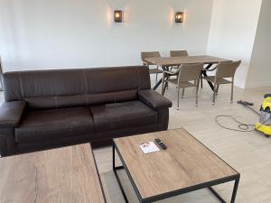 a living room with a leather couch and a table at Apartment Seadream in Blankenberge
