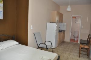 a bedroom with a bed and a kitchen with a refrigerator at VILLA SOFIA in Nea Vrasna