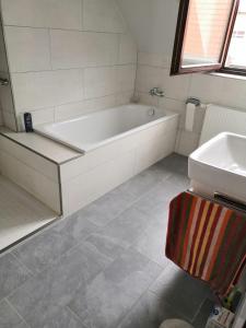 a bathroom with a bath tub and a sink at Zu Hause auf Zeit bei Marion in Bobbau