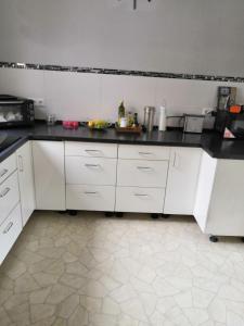 a kitchen with white cabinets and black counter tops at Zu Hause auf Zeit bei Marion in Bobbau