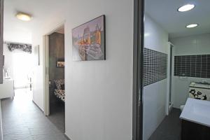 een badkamer met een witte muur met een foto op de muur bij Basic Comfort Studio Manhattan 0115 in Empuriabrava