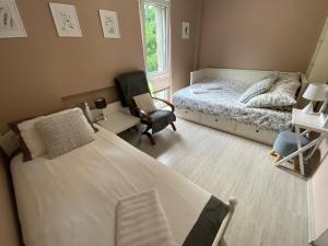 niewielka sypialnia z łóżkiem i krzesłem w obiekcie Willa nad Sołą guest house w Oświęcimiu