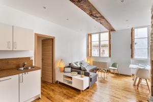 een keuken en woonkamer met een bank en een tafel bij Le Cerf Volant - une pépite à l'Intramuros in Saint-Malo