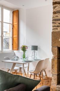 - une salle à manger blanche avec une table et des chaises blanches dans l'établissement Le Cerf Volant - une pépite à l'Intramuros, à Saint-Malo