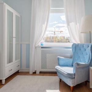 uma cadeira azul num quarto com uma janela em Elegant near Old Town - free parking em Gdansk