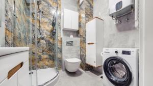 a bathroom with a washing machine and a washer at Apartamenty Sun & Snow Enklawa in Mielno