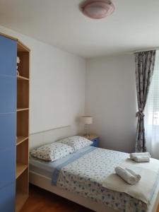 a small bedroom with a bed and a window at Apartment Tina in Split