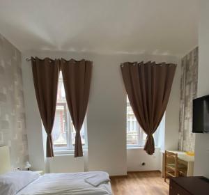 een slaapkamer met bruine gordijnen, een bed en een televisie bij Easy Star Hotel in Boedapest