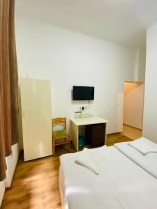 a room with two beds and a desk and a tv at Easy Star Hotel in Budapest