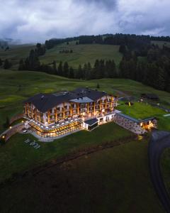 een luchtzicht op een groot gebouw op een heuvel bij Brunelle Seiser Alm Lodge in Alpe di Siusi