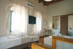 a bedroom with two beds and a mirror at Villa Apaggio in Plaka